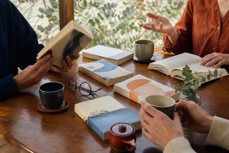 カフェのテーブルで本を囲み語り合う読書会